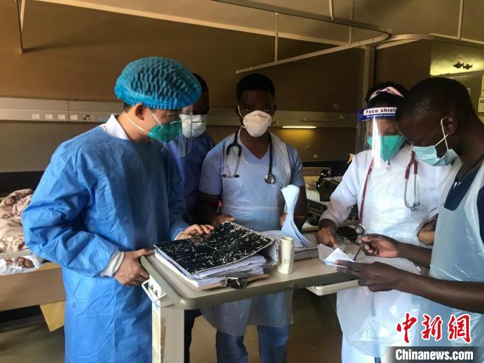 周锐承担博兹瓦纳大学医学生门诊、病房临床带教任务，图为他(左一)向同事传授经验。 福建医科大学孟超肝胆医院供图