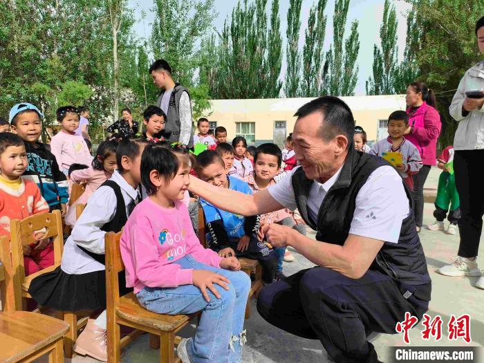 退伍老兵练志强与学校学生亲切交谈。 李伶 摄