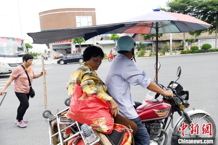 “担担军”搭乘摩托车到距离玉林火车站更远的地方去摆卖。 蒋雪林 摄
