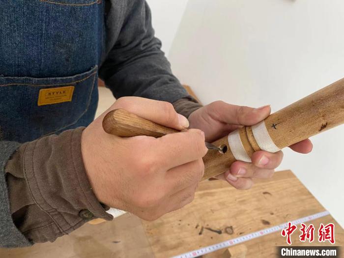 图为曹昊在对尺八进行修孔制作。 赵丹媚 摄